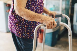 an elderly woman walking with a walker